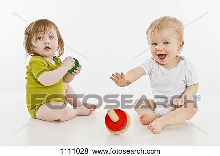 Two babies playing together View Large Photo Image Stock Photo - Two babies playing together. Fotosearch