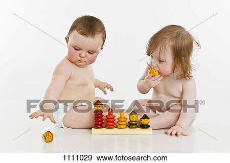Two baby girls playing together View Large Photo Image Stock Photo - Two baby girls playing together. Fotosearch