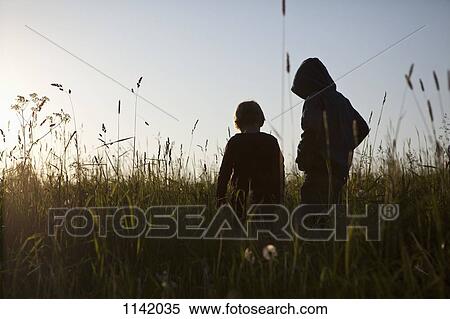 Stock Photography - Two boys standing in a field. Fotosearch