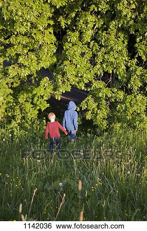Two boys walking into a forest View Large Photo Image Stock Photograph - Two boys walking into a forest. Fotosearch