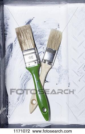 Two new house painting brushes crossing each other and lying in an old paint tray View Large Photo Image Stock Image - Two new house painting brushes crossing each other and lying in an old paint tray. Fotosearch