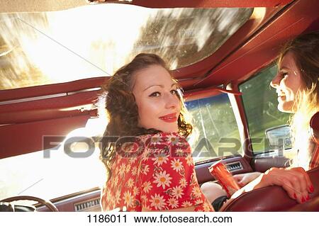 Two rockabilly women having fun in the front seat of a vintage car View Large Photo Image Stock Image - Two rockabilly women having fun in the front seat of a vintage car. Fotosearch