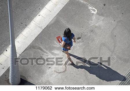 Stock Image - Walking woman carrying files. Fotosearch