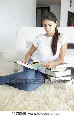 Woman at home leaning on books and reading View Large Photo Image Stock Photograph - Woman at home leaning on books and reading. Fotosearch