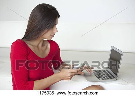 Woman in red using phone and laptop View Large Photo Image Stock Photography - Woman in red using phone and laptop. Fotosearch