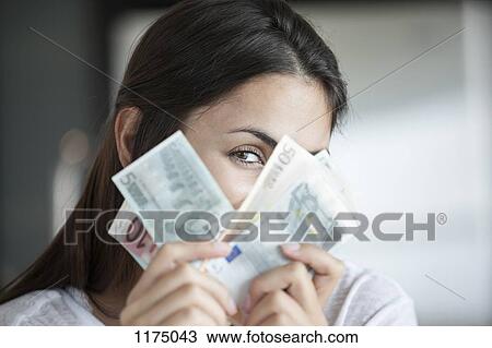 Woman peeking behind euro notes View Large Photo Image Stock Image - Woman peeking behind euro notes. Fotosearch