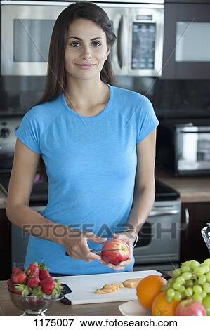 Woman preparing fruit in kitchen View Large Photo Image Stock Photo - Woman preparing fruit in kitchen. Fotosearch