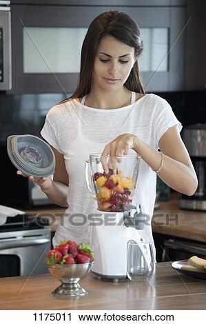 Woman putting fruit into blender View Large Photo Image Stock Image - Woman putting fruit into blender. Fotosearch