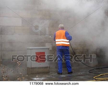 Worker removing graffiti with pressure hose View Large Photo Image Stock Photo - Worker removing graffiti with pressure hose. Fotosearch