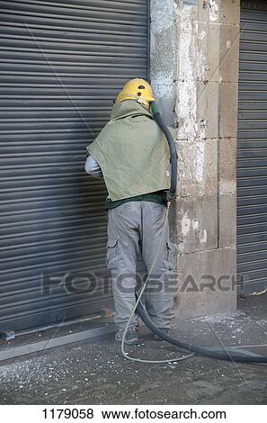Worker sandblasting stone wall View Large Photo Image Stock Photo - Worker sandblasting stone wall. Fotosearch