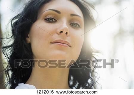 Stock Photograph - A beautiful woman back lit by sunlight. Fotosearch