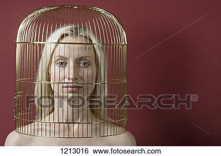 A beautiful woman with a gold birdcage over her head View Large Photo Image Stock Photograph - A beautiful woman with a gold birdcage over her head. Fotosearch
