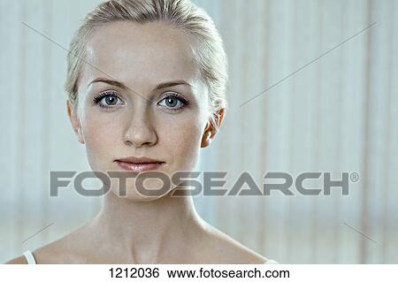 A beautiful young woman wearing a tank top and staring serenely View Large Photo Image Stock Photograph - A beautiful young woman wearing a tank top and staring serenely. Fotosearch
