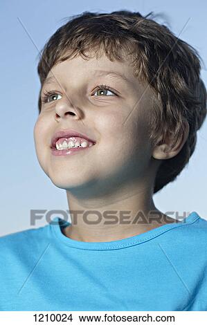 Picture - A boy looking off camera with excitement. Fotosearch