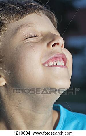 Picture - A boy with his eyes closed and a joyous expression. Fotosearch
