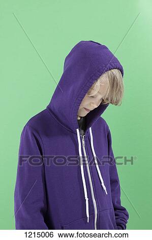 A boy with the hood of his sweatshirt up looking down shyly View Large Photo Image Stock Photograph - A boy with the hood of his sweatshirt up looking down shyly . Fotosearch