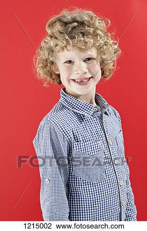 A Boy With Tousled Curly Blond Hair Smiling At The Camera Stock