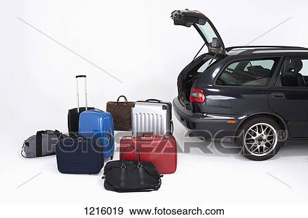 Stock Photo - A bunch of different pieces of luggage next to an open car trunk. Fotosearch