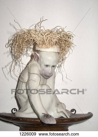 Stock Photo - A ceramic monkey with straw hair. Fotosearch