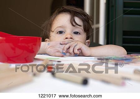 A child leaning on a table littered with colored pencils and art supplies View Large Photo Image Stock Photo - A child leaning on a table littered with colored pencils and art supplies. Fotosearch
