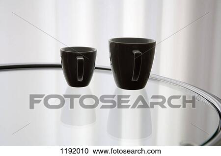 A coffee cup and an espresso cup reflected on a glass table View Large Photo Image Stock Image - A coffee cup and an espresso cup reflected on a glass table. Fotosearch