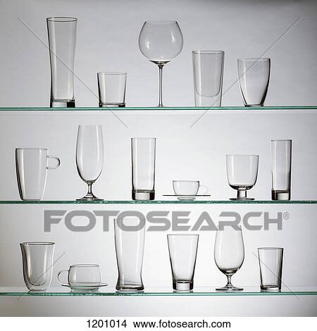 Picture - A collection of various types of drinking glasses arranged neatly on three shelves. Fotosearch