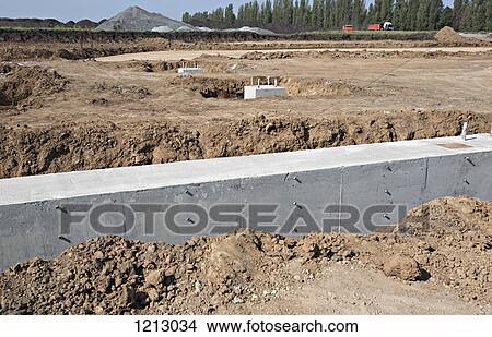 Picture - A concrete foundation wall at a construction site. Fotosearch
