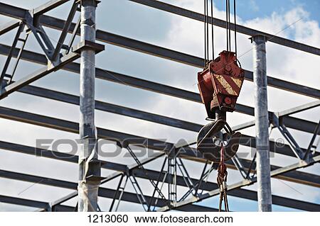 Stock Image - A crane hook attached to cables at a construction site. Fotosearch