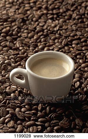 Stock Photo - A cup of coffee on coffee beans. Fotosearch