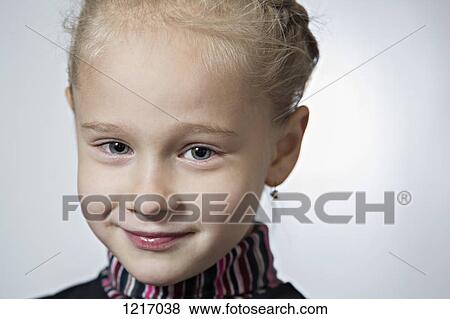 Stock Photo - A fashionable young girl wearing earrings and her hair braided. Fotosearch