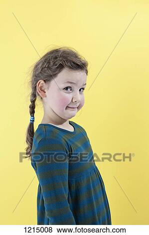 Stock Photo - A girl looking mischievously into the camera. Fotosearch