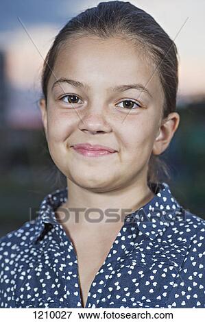 Stock Photo - A girl smiling and looking into the camera. Fotosearch