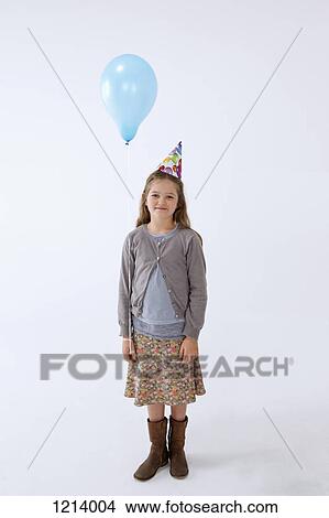 A girl wearing a party hat and holding a balloon View Large Photo Image Picture - A girl wearing a party hat and holding a balloon. Fotosearch