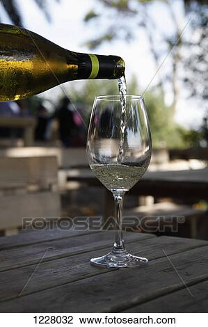 A glass of white wine being poured at a vineyard wine tasting View Large Photo Image Stock Image - A glass of white wine being poured at a vineyard wine tasting. Fotosearch