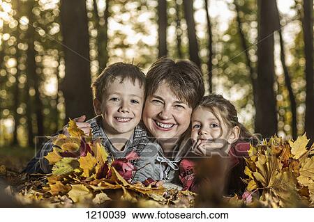 A grandmother posing with two of her grandchildren in nature View Large Photo Image Stock Photo - A grandmother posing with two of her grandchildren in nature. Fotosearch