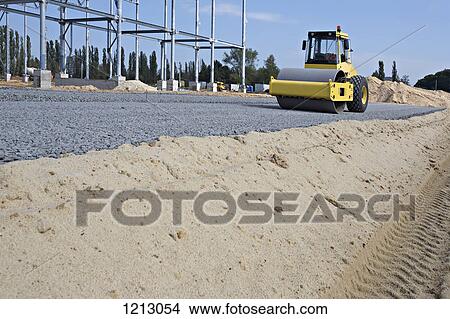 A gravel road steamroller next to a construction frame View Large Photo Image Picture - A gravel road steamroller next to a construction frame. Fotosearch