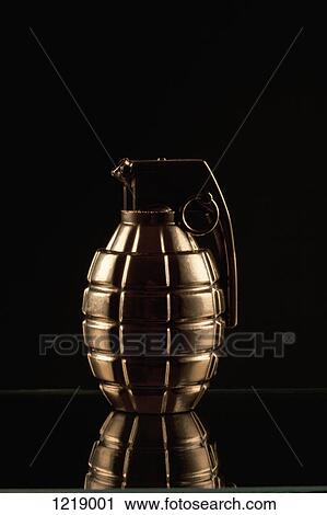 Stock Image - A grenade on a shiny surface, black background. Fotosearch
