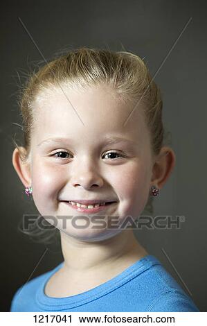 Stock Image - A grinning young girl wearing earrings. Fotosearch