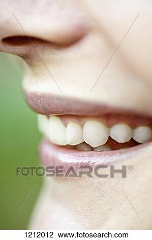 Stock Image - A grinning young woman, close-up of her mouth. Fotosearch