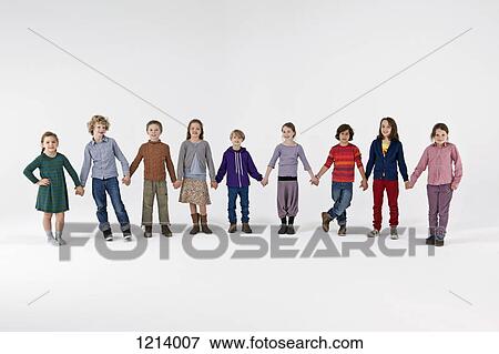 A group of kids standing in a row and holding hands View Large Photo Image Stock Photo - A group of kids standing in a row and holding hands. Fotosearch