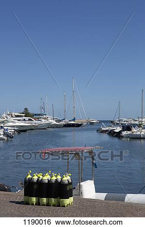 A group of scuba diving oxygen tanks on a jetty at a marina, Agrustos, Italy View Large Photo Image Stock Photograph - A group of scuba diving oxygen tanks on a jetty at a marina, Agrustos, Italy. Fotosearch