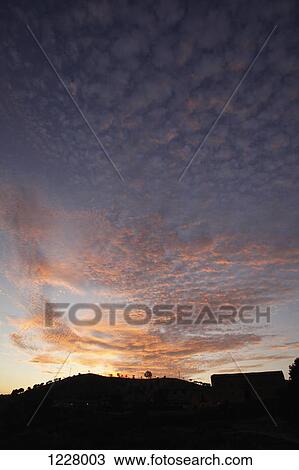 Stock Image - A hill in silhouette against a dusk sky. Fotosearch