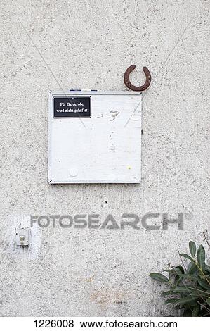 Stock Photo - A horseshoe and a sign hanging on a wall saying "not responsible for belongings". Fotosearch