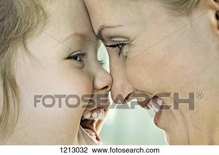 A laughing girl touching noses with her smiling mother, close-up View Large Photo Image Stock Image - A laughing girl touching noses with her smiling mother, close-up. Fotosearch