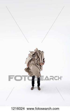 Picture - A man carrying an impossibly large ball of crumpled construction paper. Fotosearch
