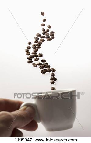 A man holding a coffee cup with coffee beans floating above View Large Photo Image Stock Photo - A man holding a coffee cup with coffee beans floating above. Fotosearch