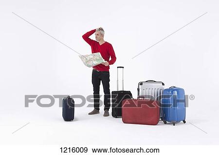 A man holding a map and scratching his head, surrounded by luggage View Large Photo Image Stock Photo - A man holding a map and scratching his head, surrounded by luggage. Fotosearch
