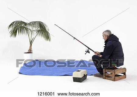 Stock Image - A man pretend fishing in pretend water. Fotosearch
