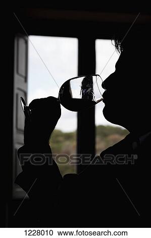 Stock Image - A man taking a sip of wine . Fotosearch