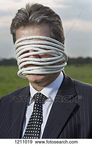 A mature businessman with rope wrapped around his face View Large Photo Image Stock Photo - A mature businessman with rope wrapped around his face. Fotosearch
